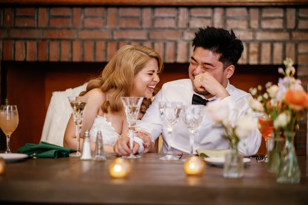 Bride and groom laughing to wedding toasts