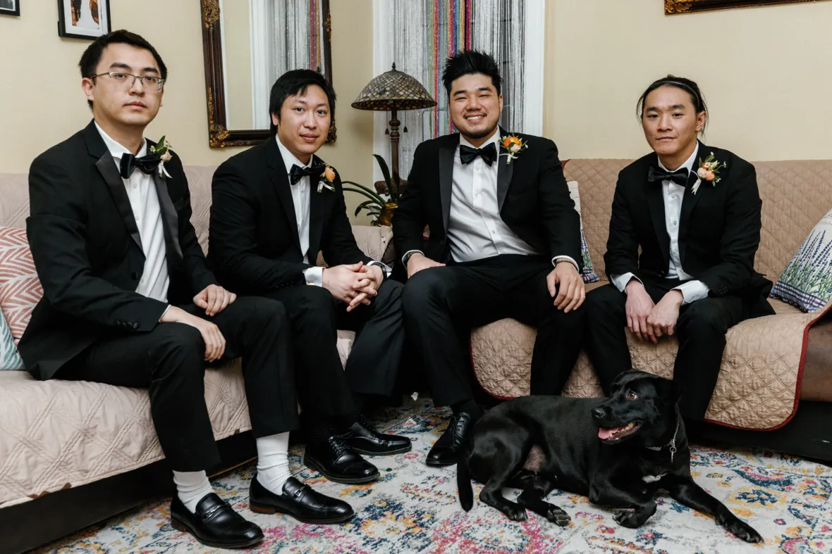 Groom with groomsmen sitting on sofa