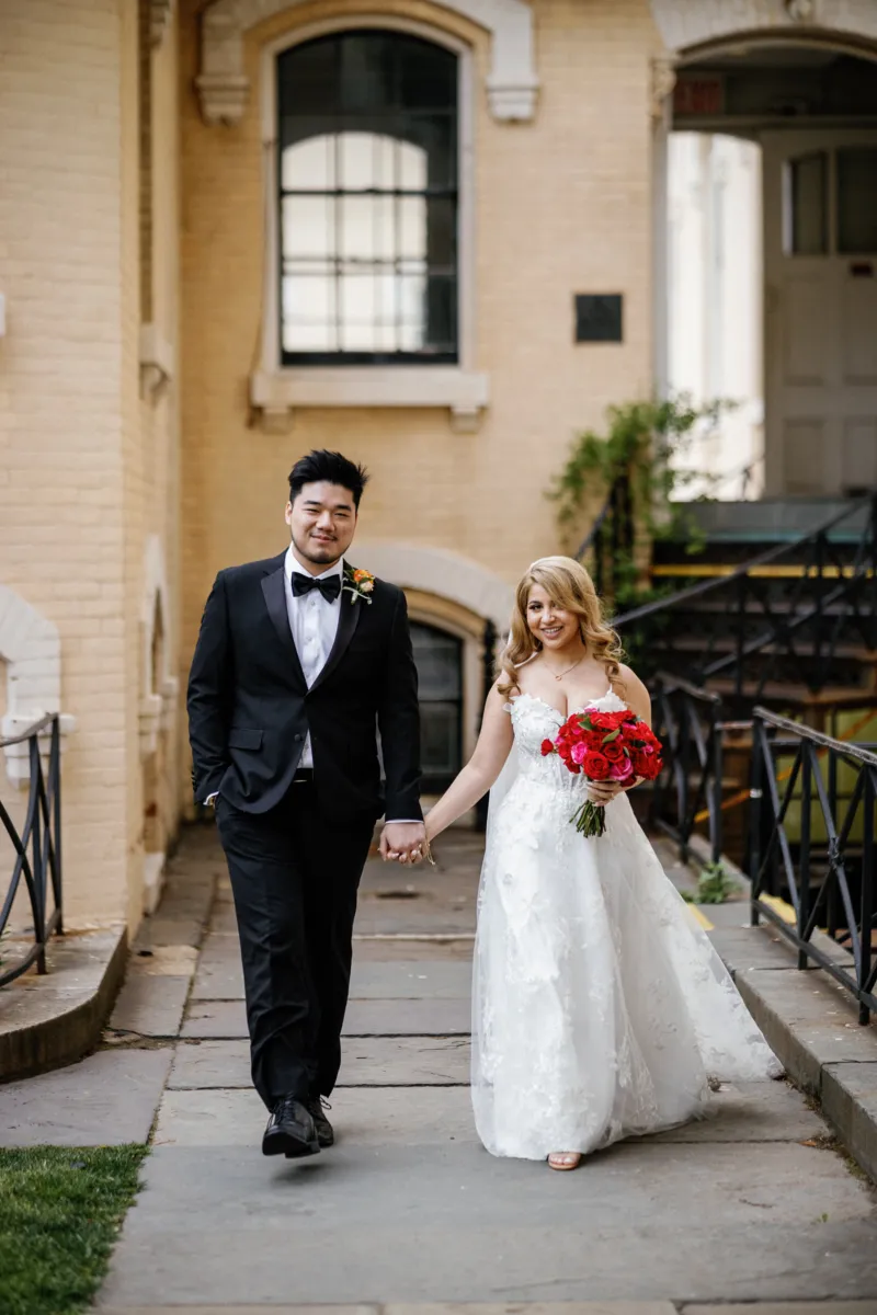 Bride and groom holding hands and walking