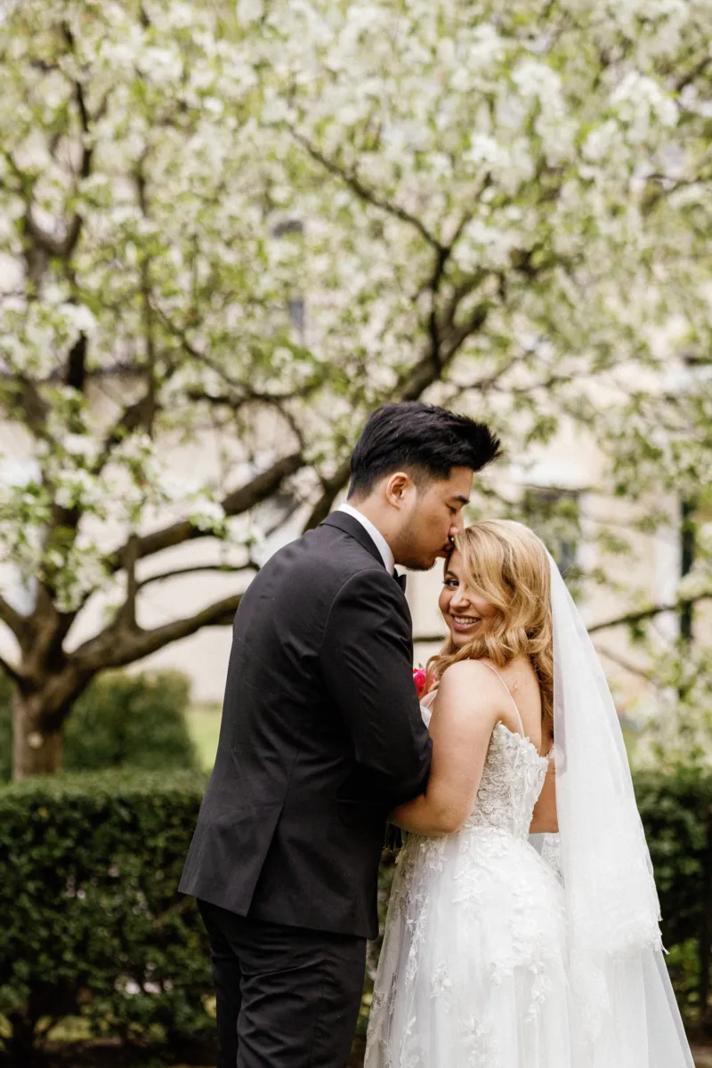 Groom kissing bride on forehead