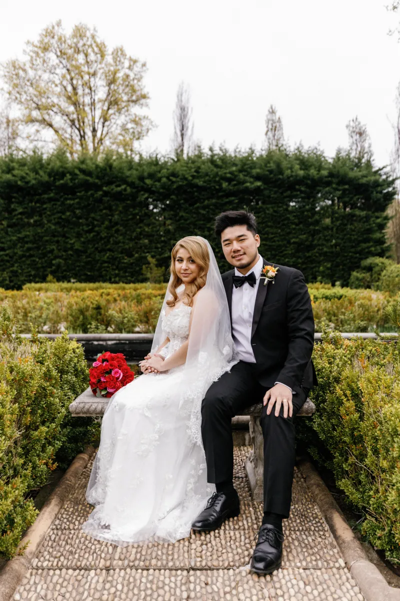 Bride and groom sitting on bench in Snug Harbor