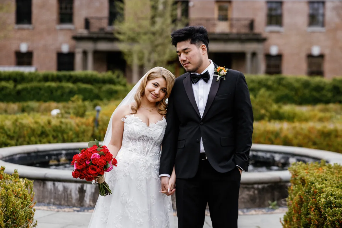 Bride leaning on grooms shoulder and holding his hand