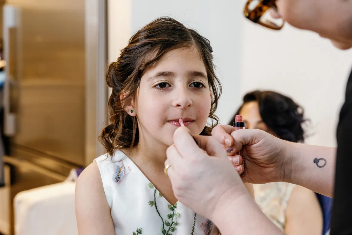 Flower girl putting lipstick on