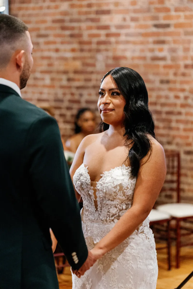 Bride holding grooms hands during wedding ceremony