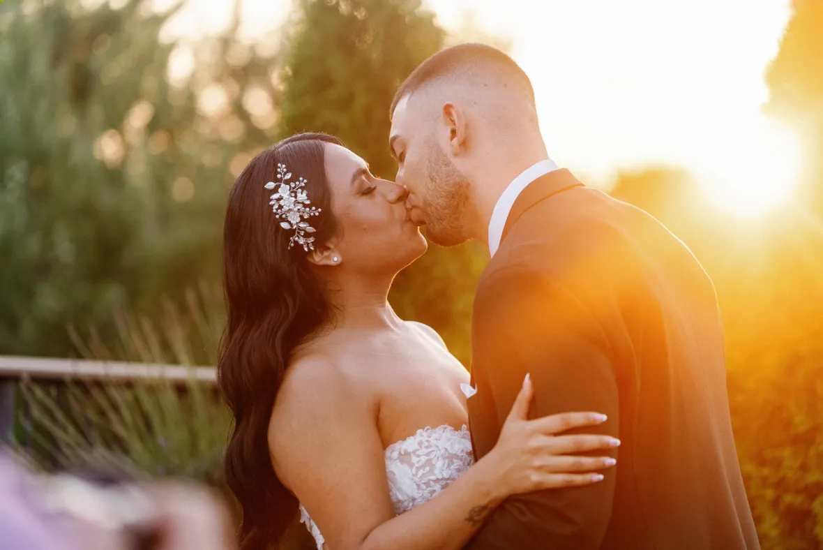 Bride and groom kissing in sunset