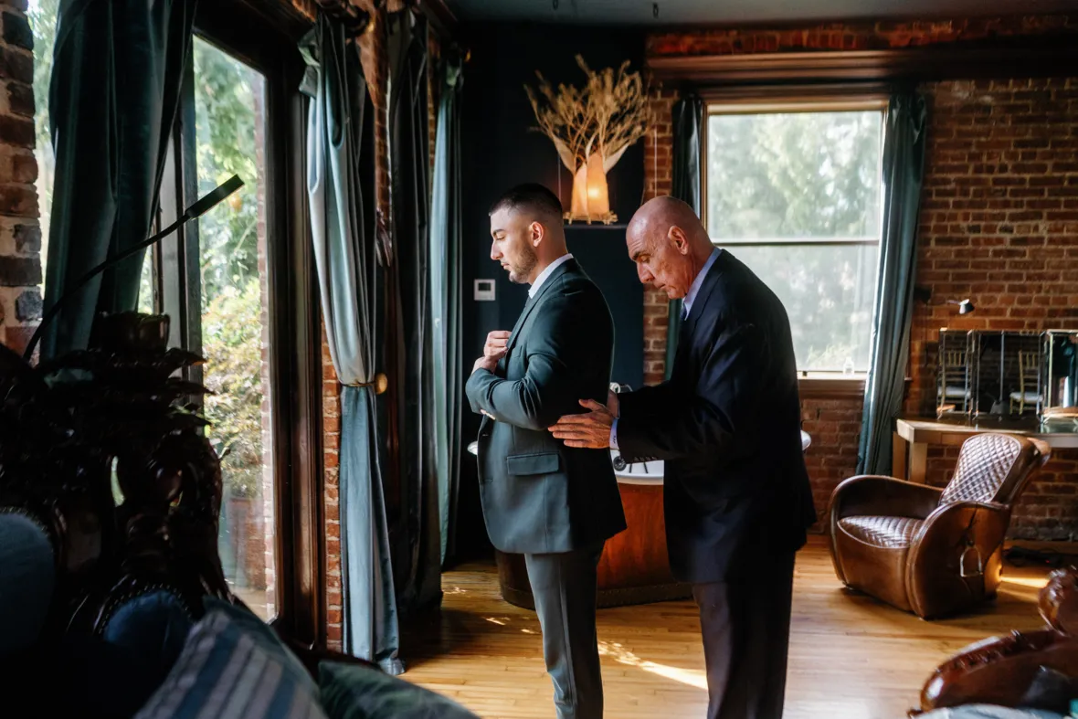 Father helping groom put the suit on