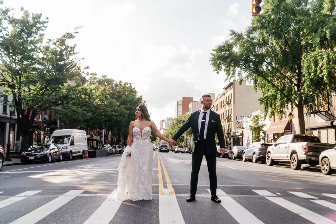 Bride and groom holding hands and standing in the middle of street in Brooklyn