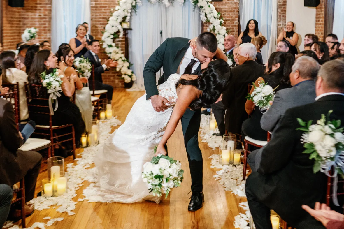 Groom dipping the bride after wedding ceremony