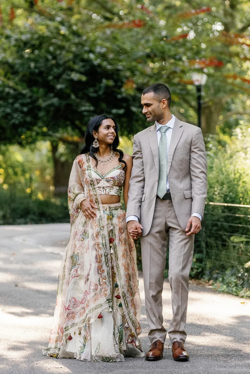 Indian bride and groom holding hands and looking at each other in Fort Greene Park