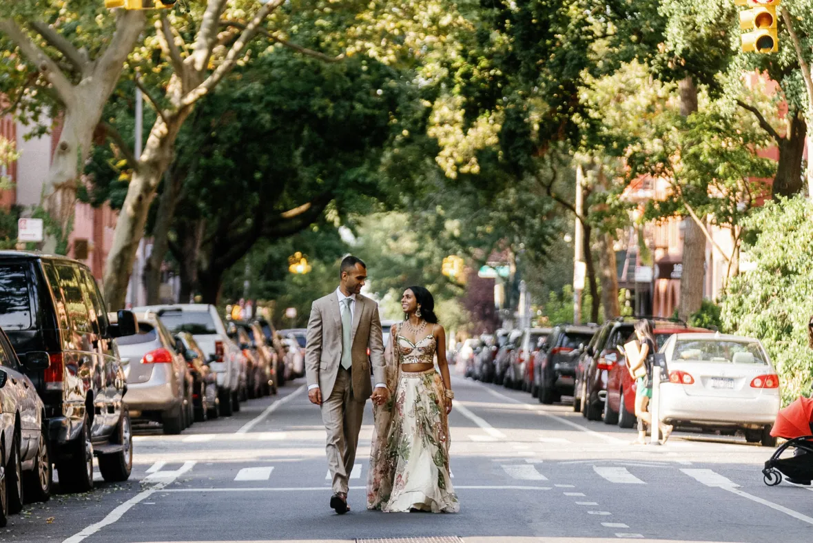 Indian bride and groom walking in the middle of street and holding hands