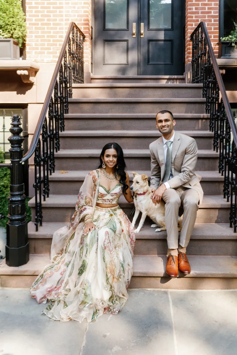 Indian bride and groom sitting on a stoop with their dog in Fort Greene Brooklyn