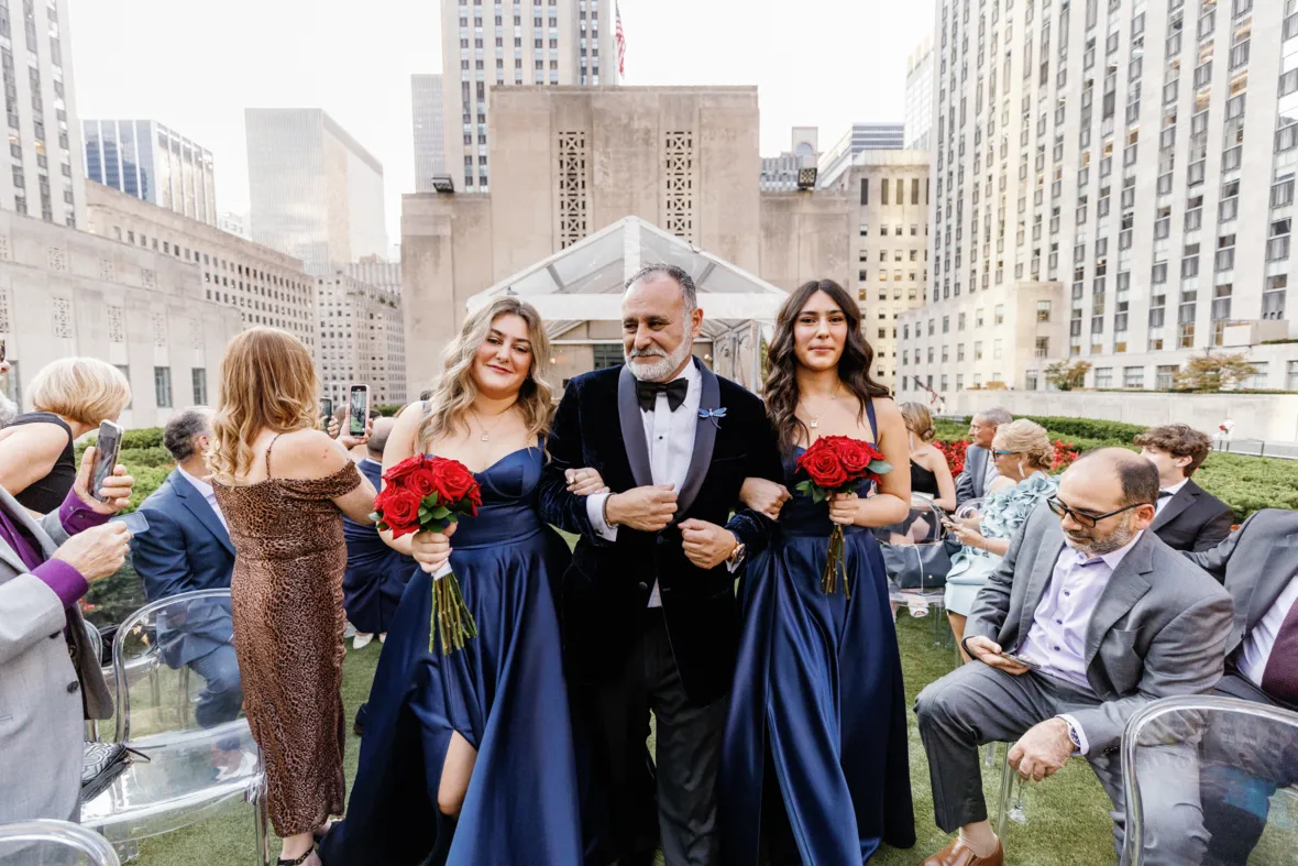 Groom walking down the aisle with daughters