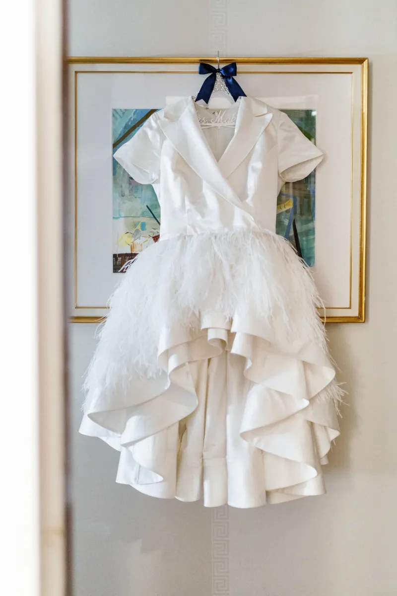 Brides wedding dress hanging on picture in hotel room