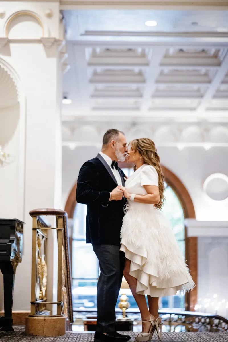 Bride and groom kissing in hallway of New York Lotte Palace hotel