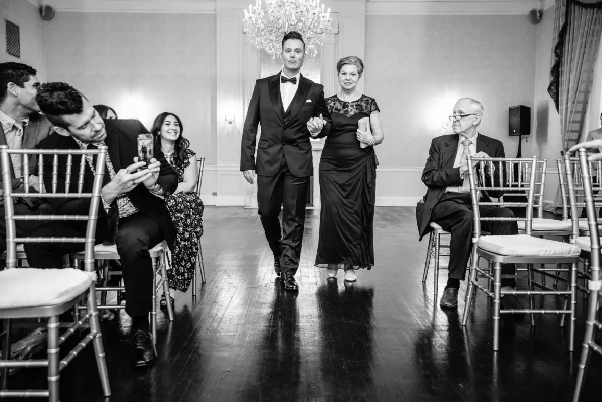 Groom walking down the aisle with mother