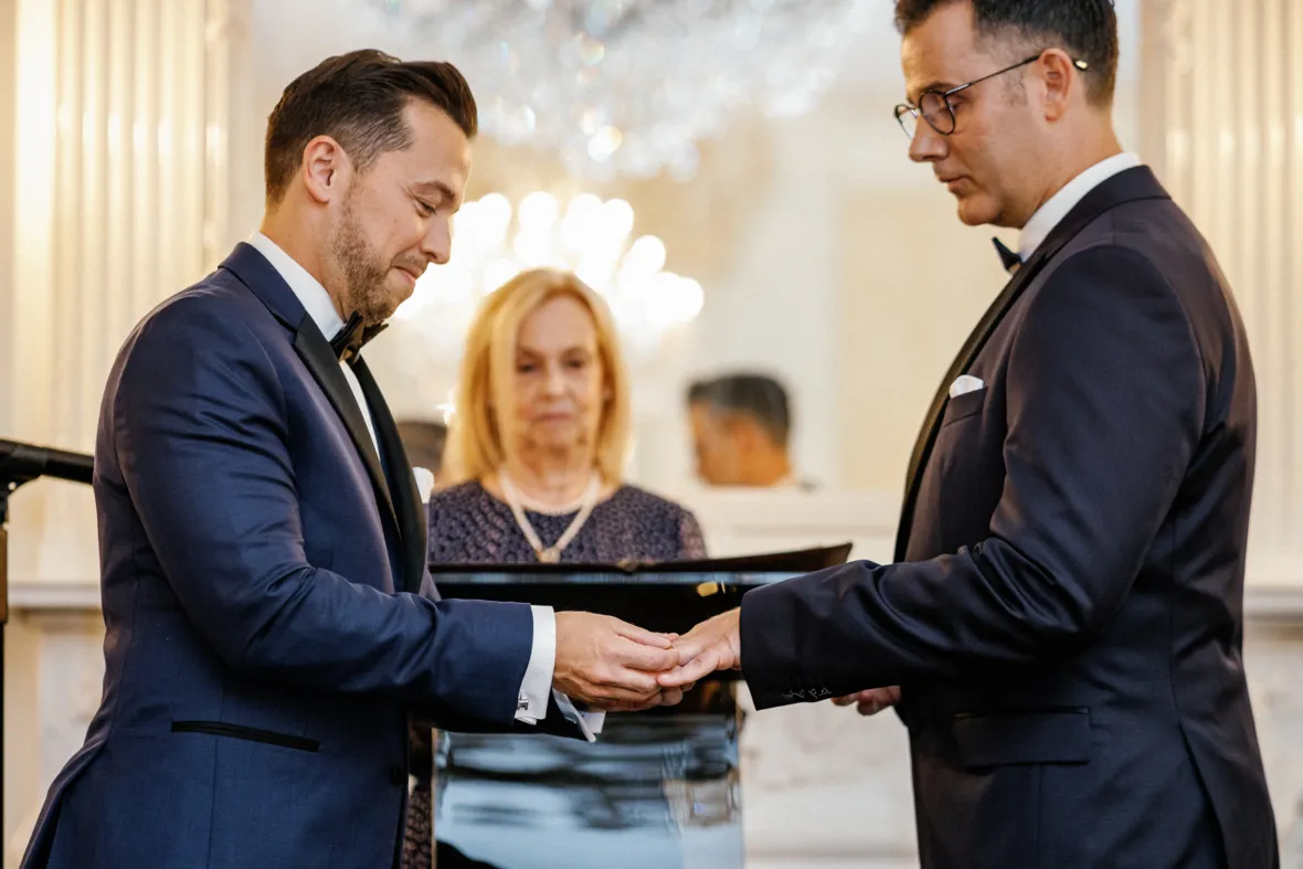 Groom putting a ring on grooms finger