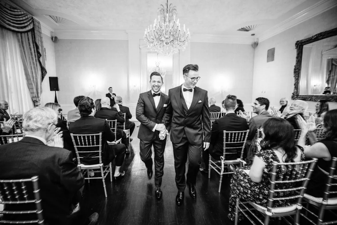 Grooms leaving same sex wedding ceremony