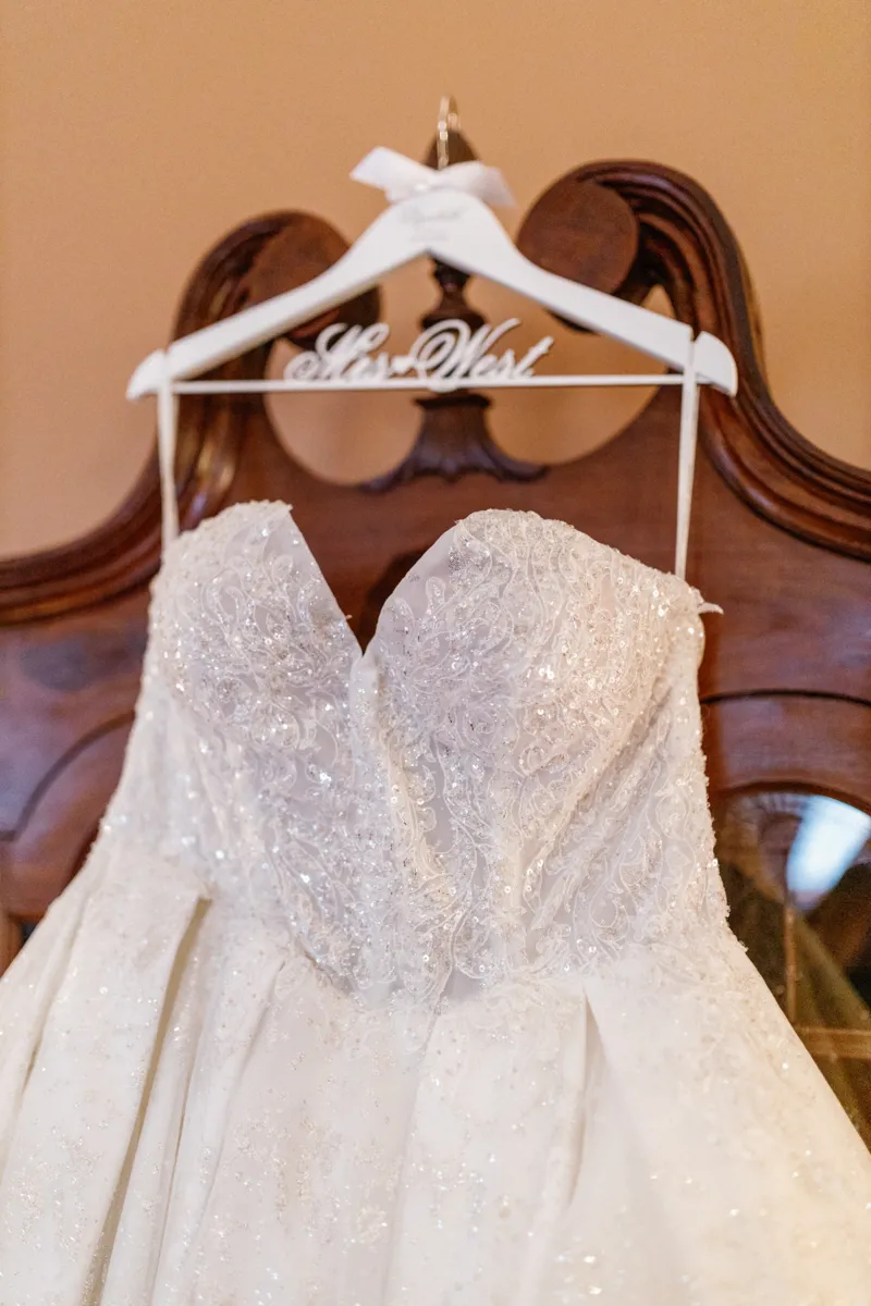 Brides wedding dress hanging on wardrobe