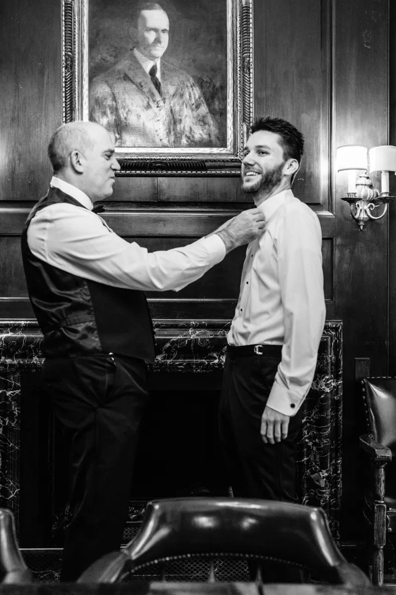 Father helping groom put the tie on