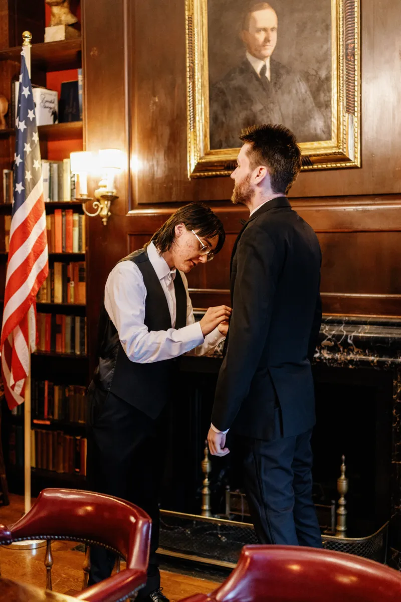 Brother helping groom put the suit on